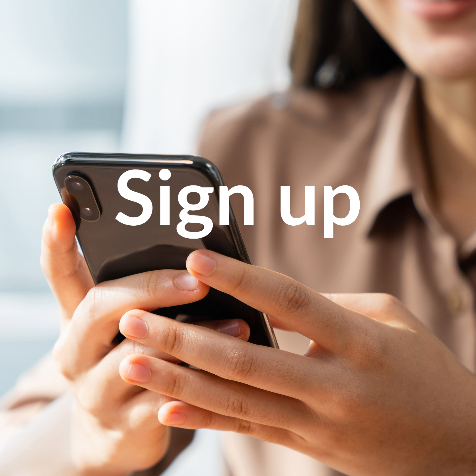 A smiling woman is looking at her phone